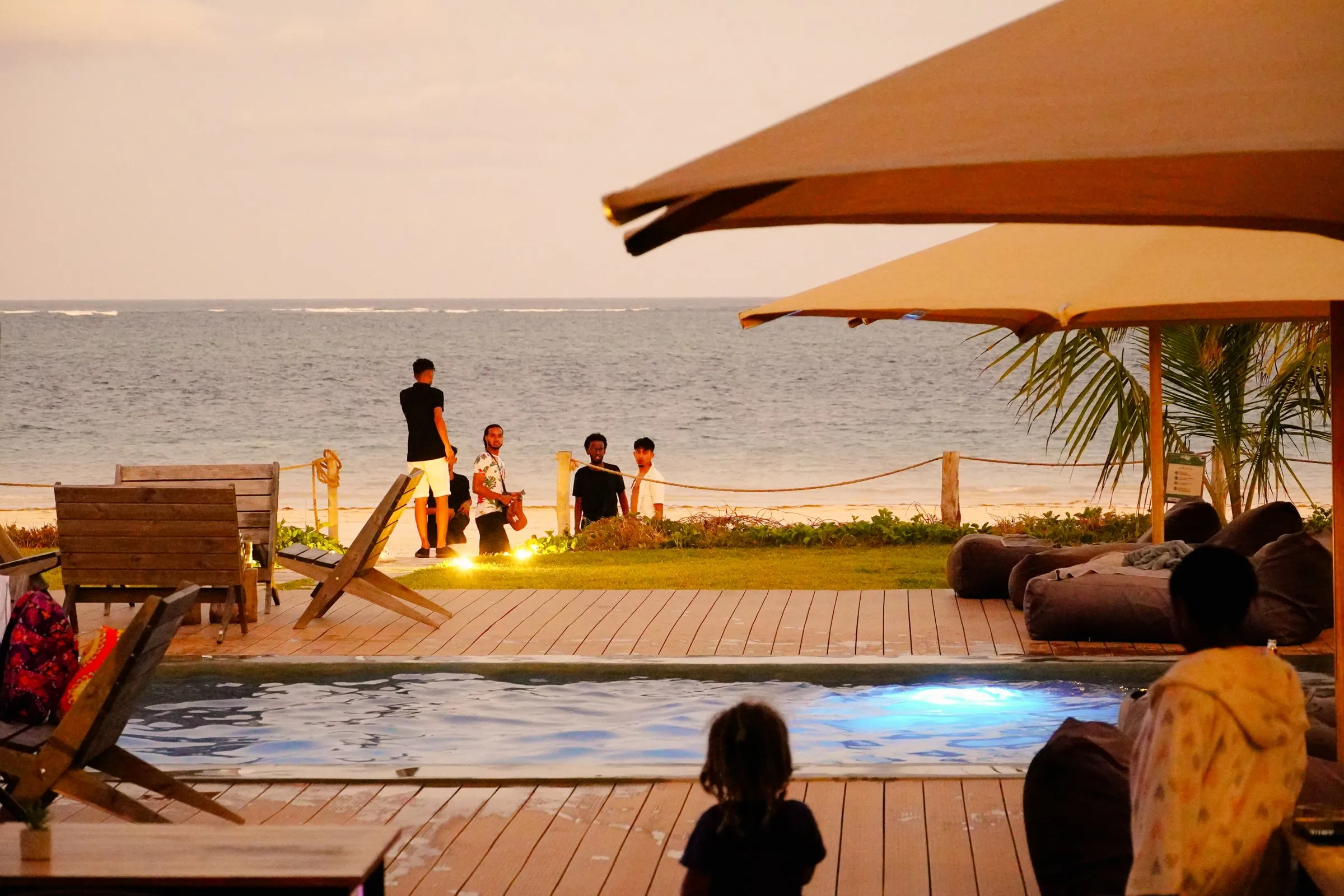 Sunset Social at dusk: guests at the pool edge as the lights come on