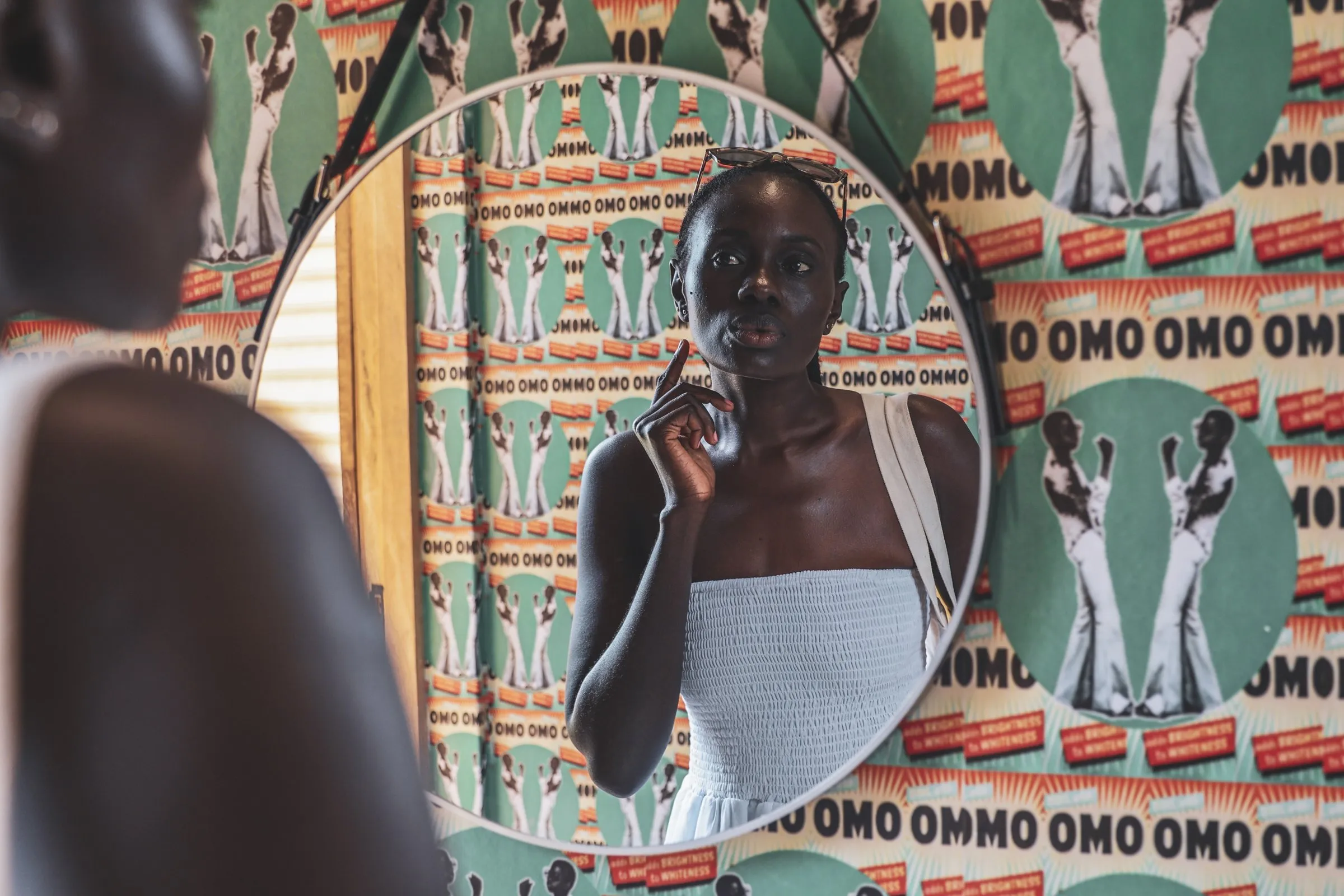 A guest in the mirror, Omo Omo print behind