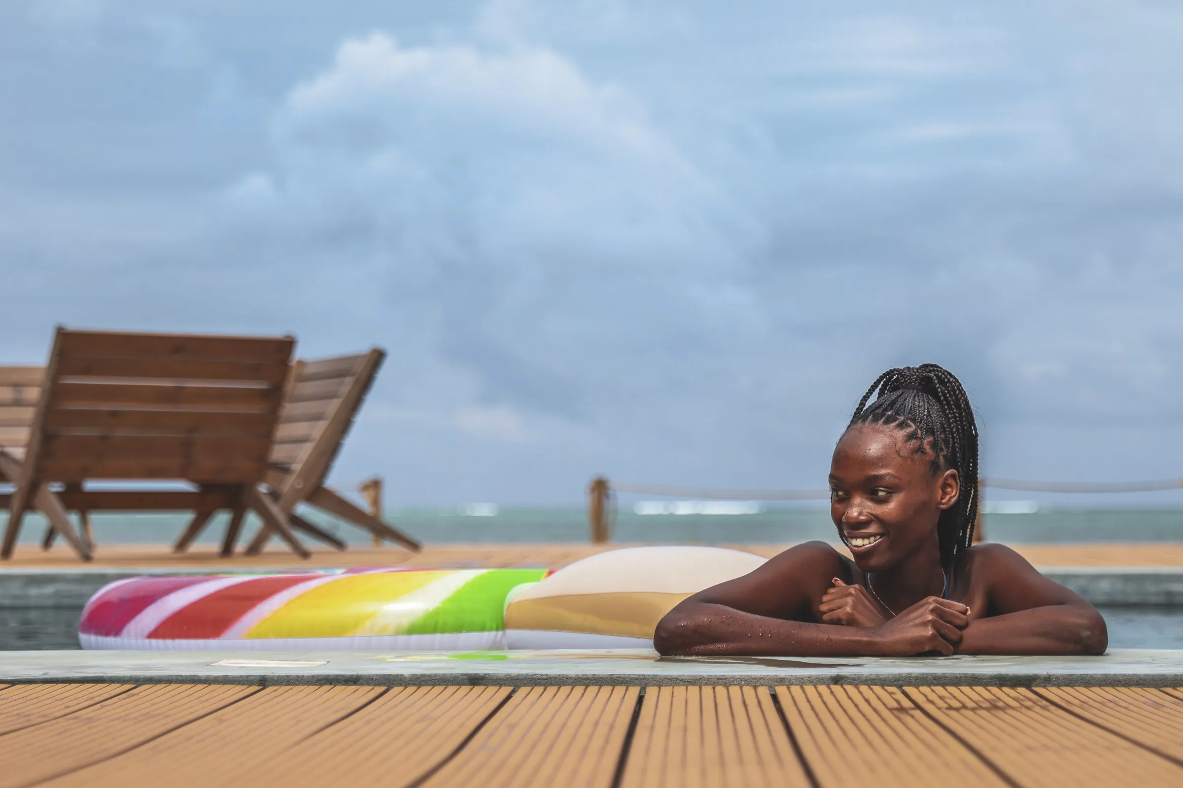 A guest leans on the pool edge, smiling