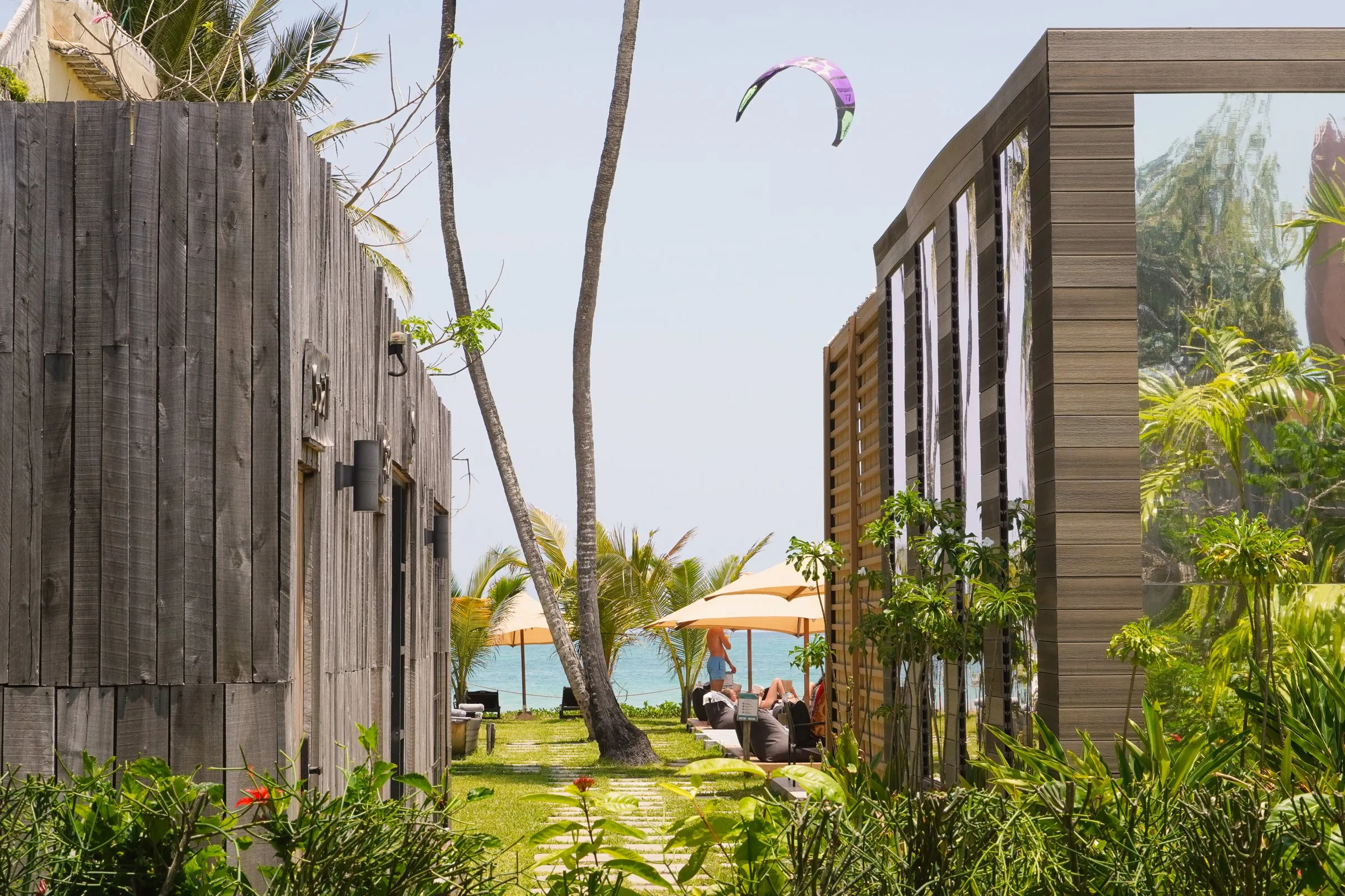 Timber cabins among the palms at LalaGalu, the sea beyond